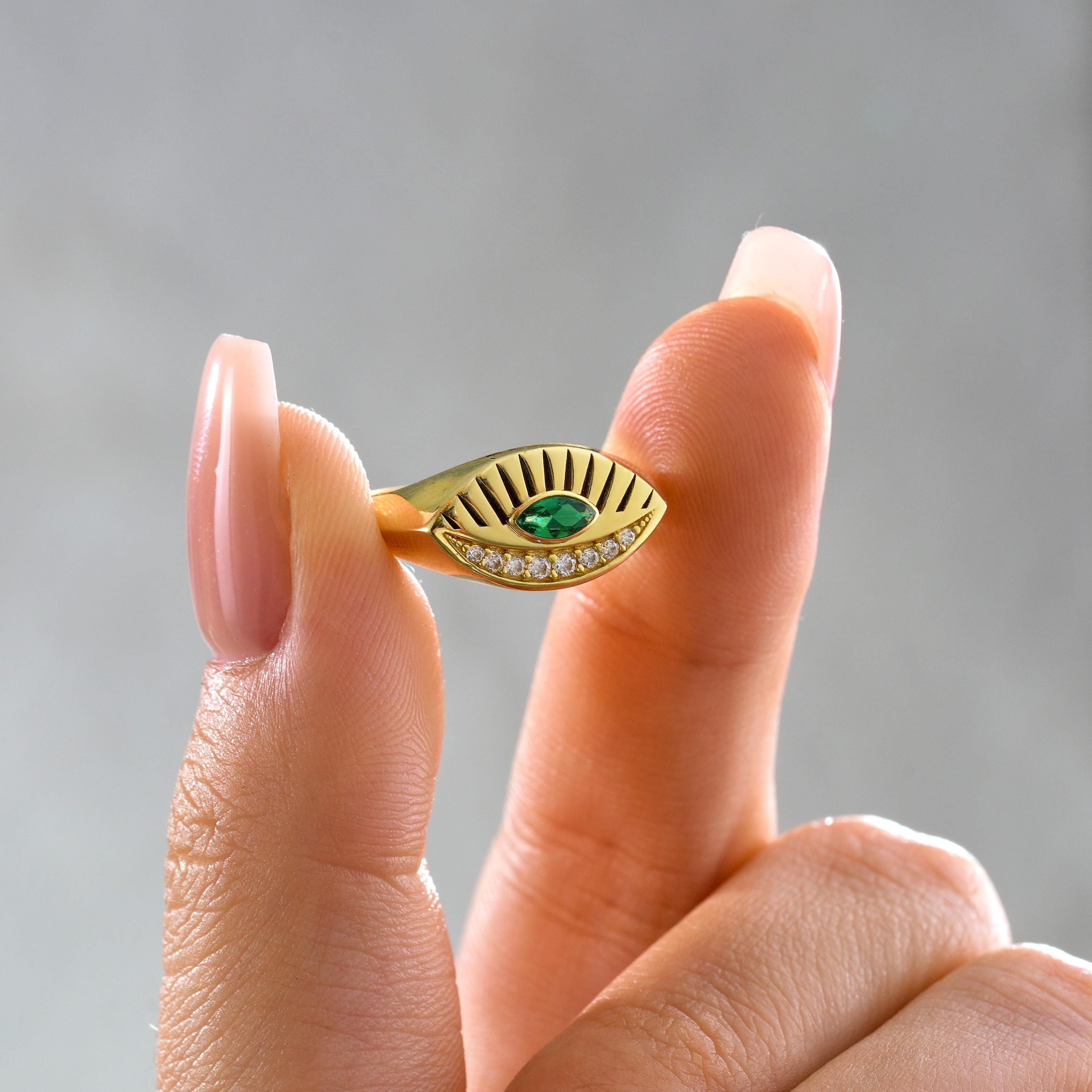 solid gold engraved evil eye ring with green emerald marquise stone and micro pave detail
