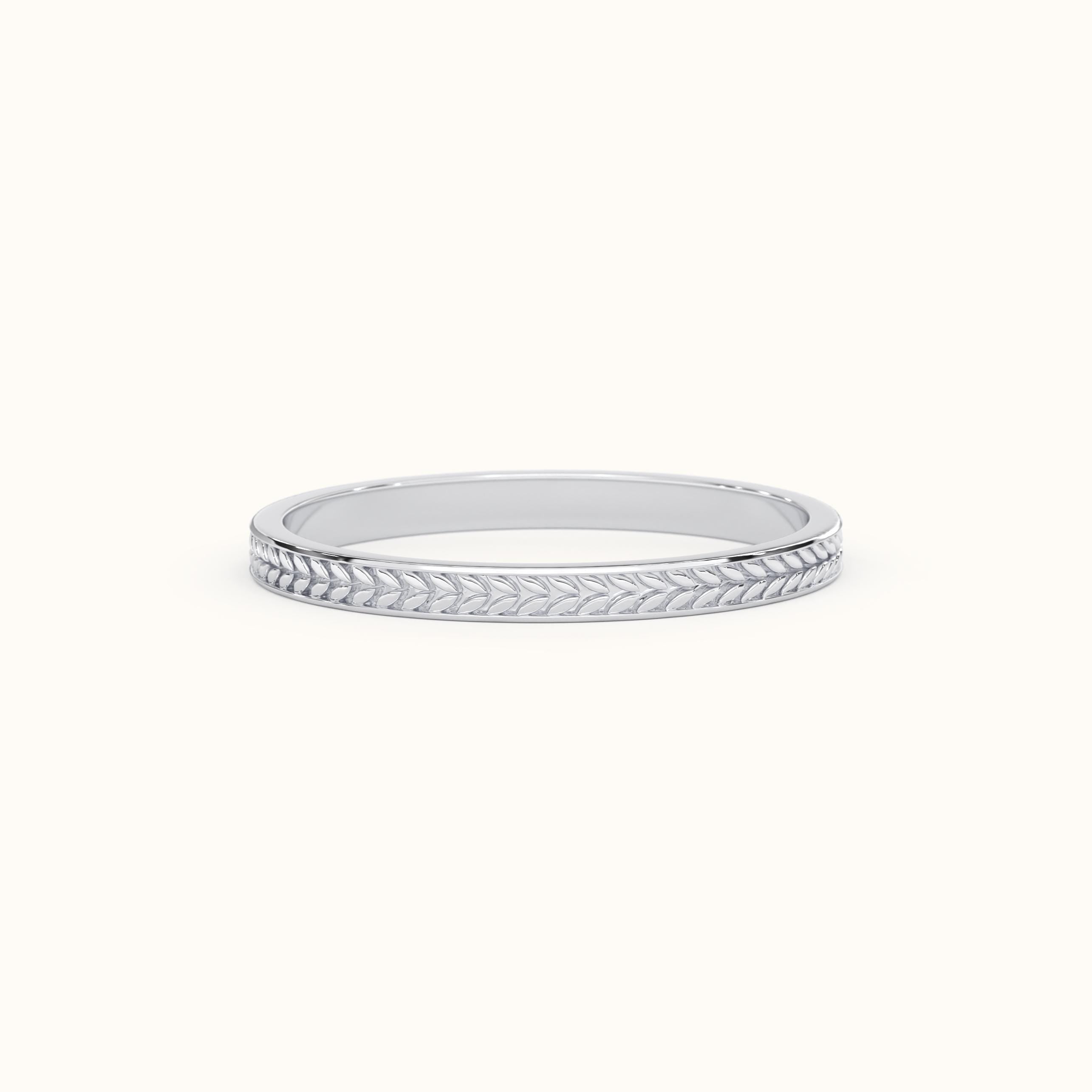May include: A thin silver band with a delicate leaf pattern engraved around the edge.