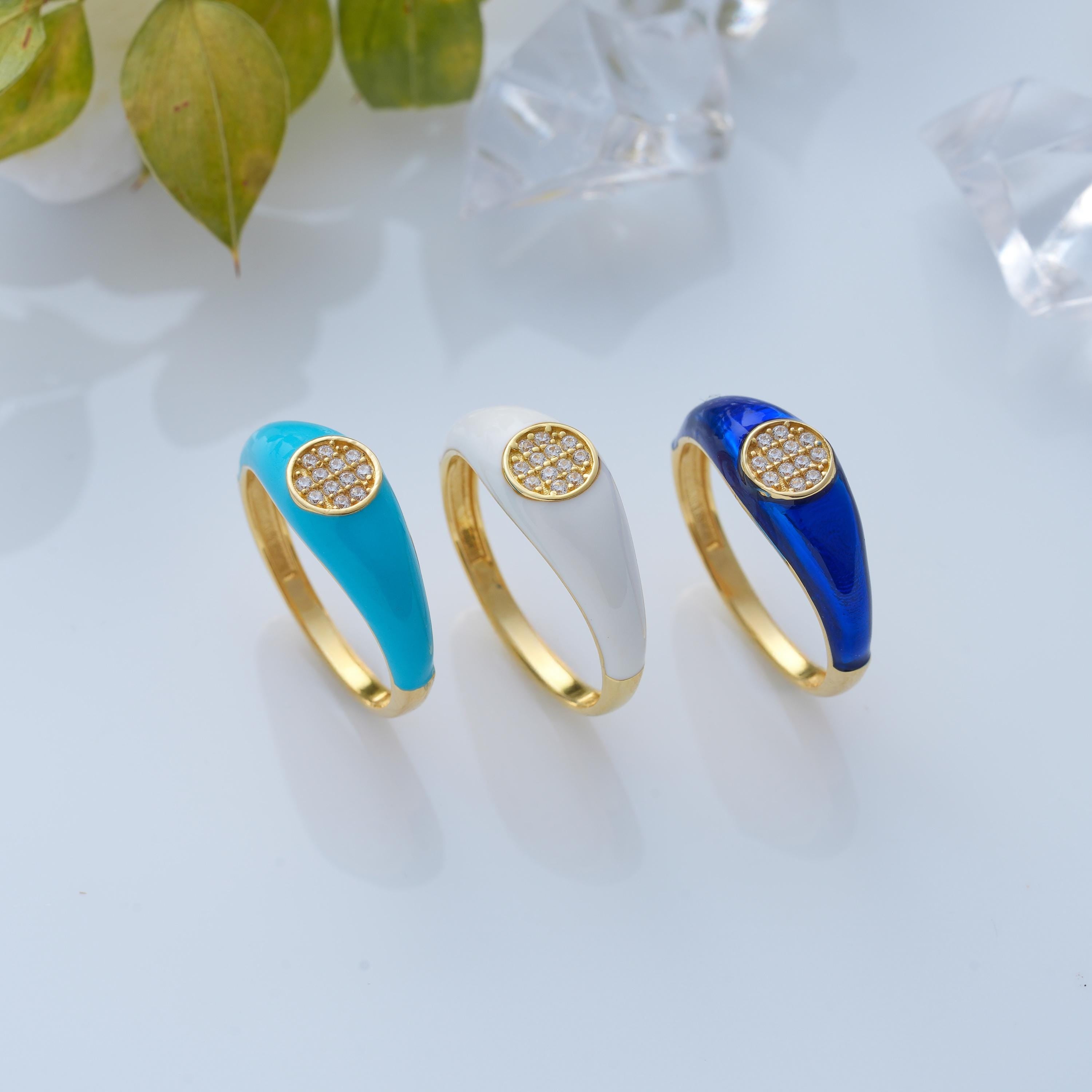 Three solid gold pave diamond signet rings in turquoise enamel, white enamel, and sapphire blue enamel