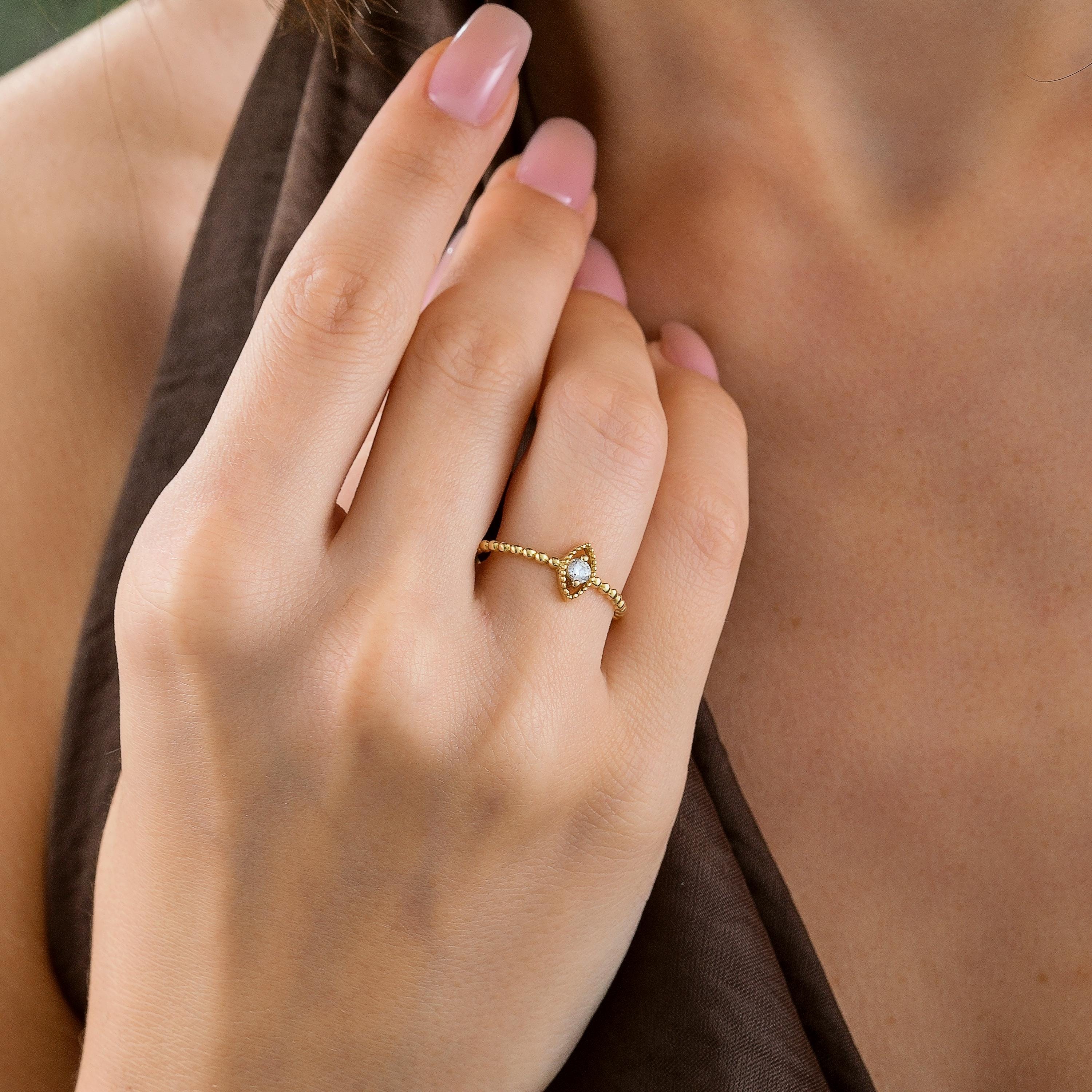 14k solid gold minimalist ring with marquise center and beaded band shown on a woman's hand
