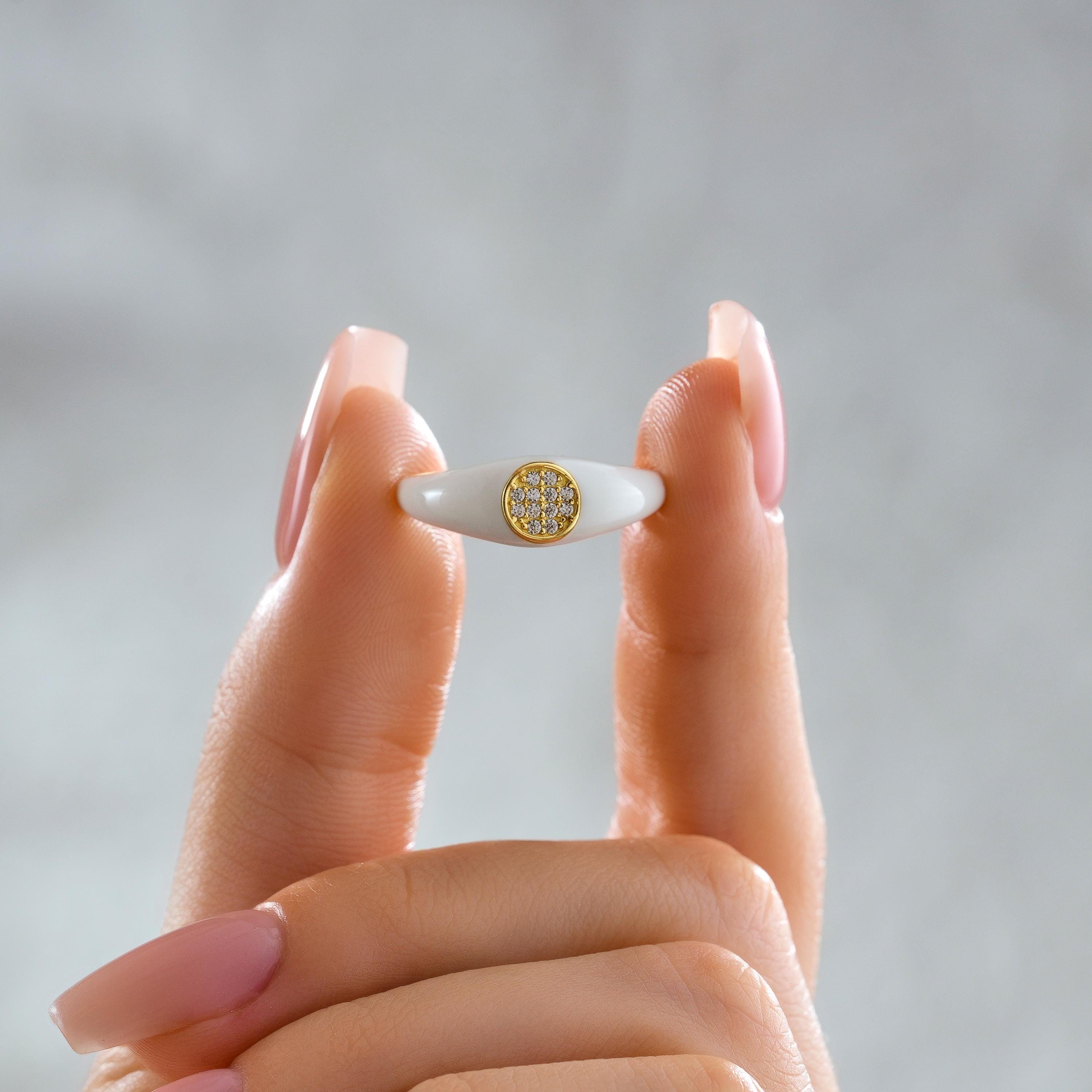 White enamel gold signet ring with bezel set pave diamonds