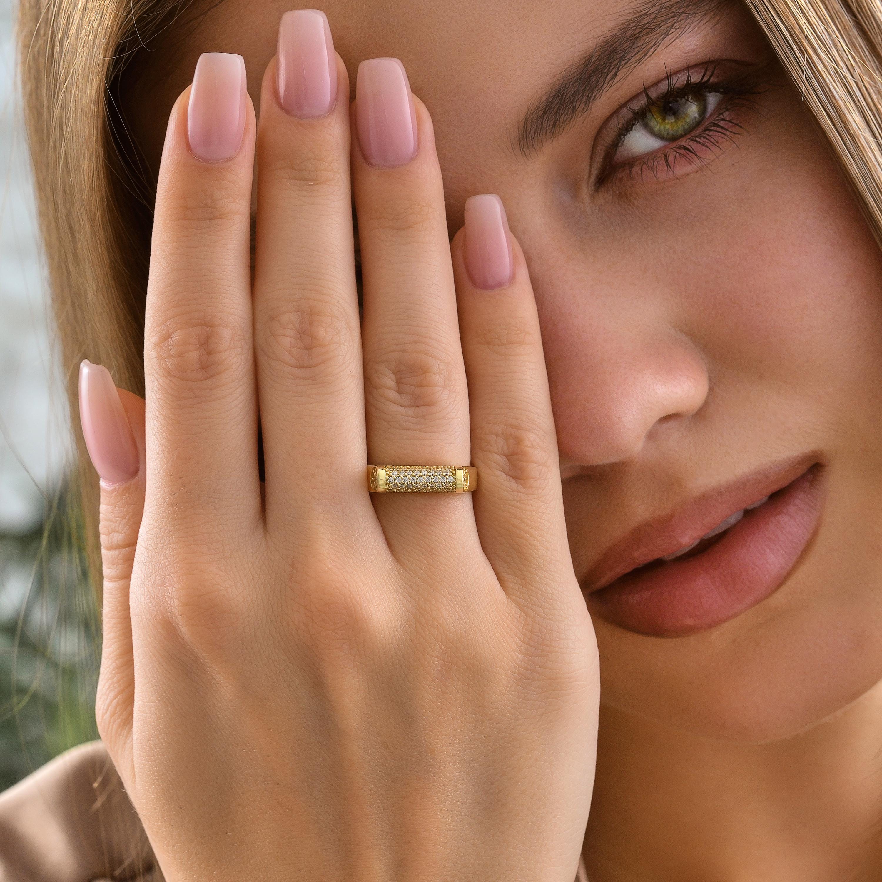 Woman wearing solid gold cylinder bar ring with micro pave CZ diamonds