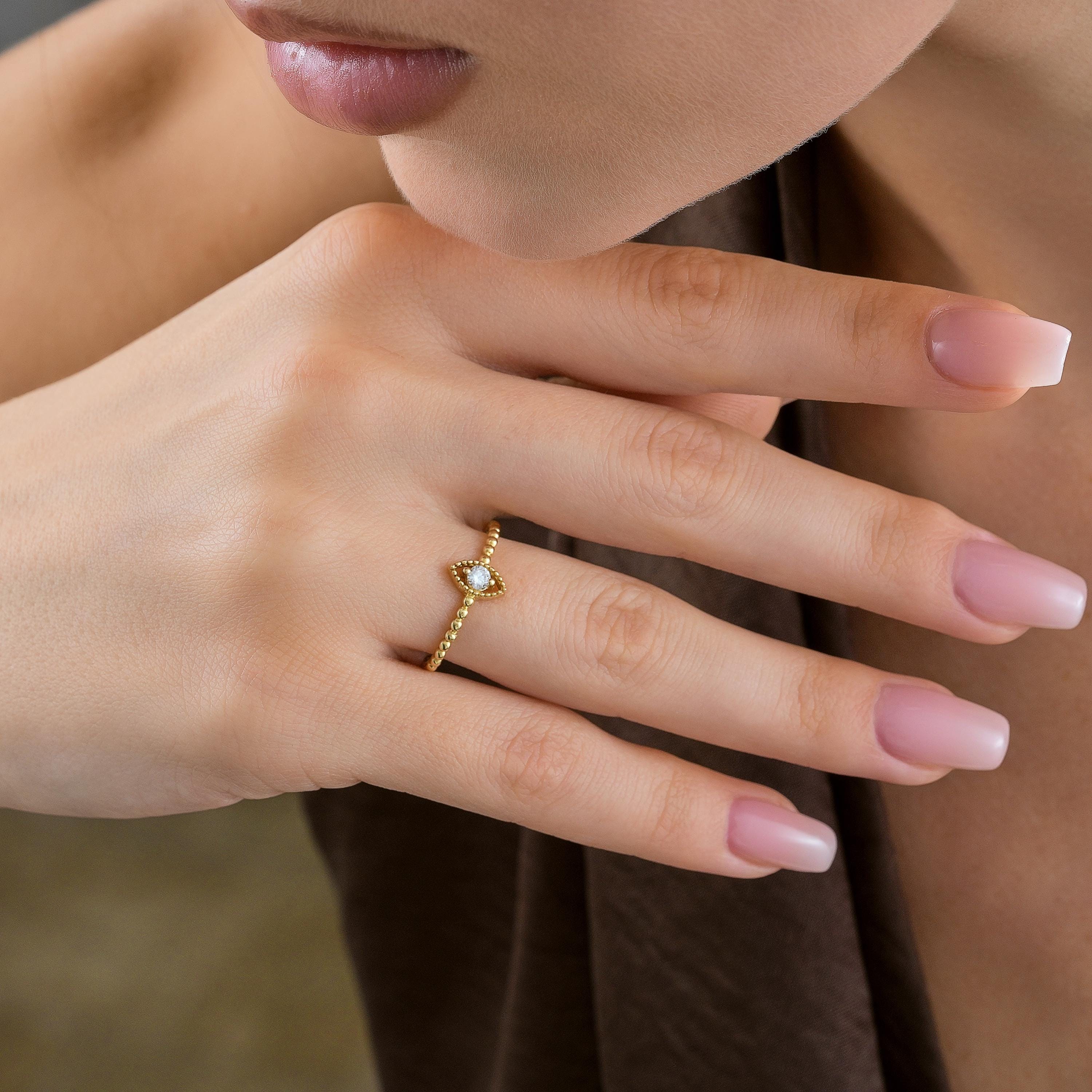 Marquise beaded solid gold CZ round diamond ring worn on a hand, highlighting its dainty and minimalist look