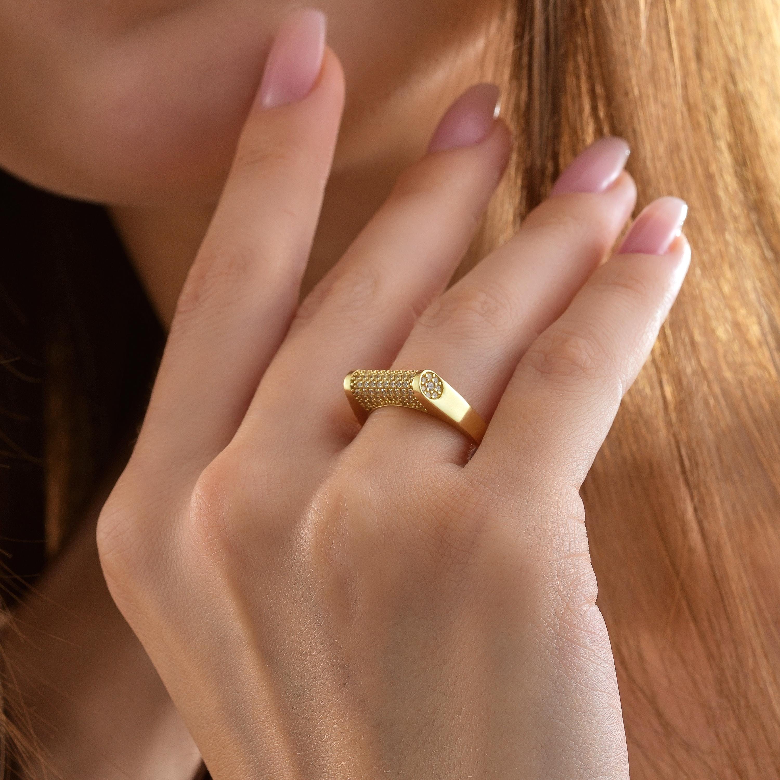 Side angle of gold cylinder ring showing round cut CZ diamonds on curved cylindrical bar