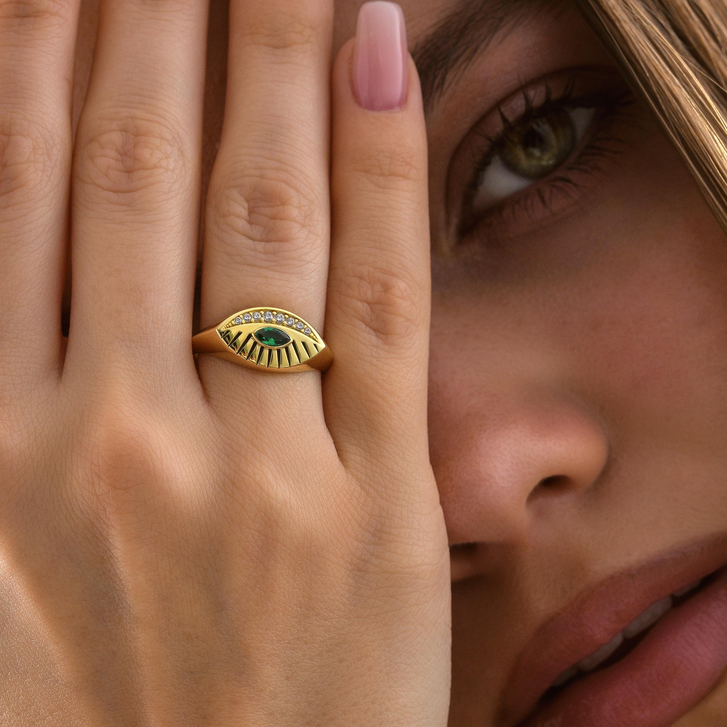 14K gold eye inspired ring with green center stone and engraved rays