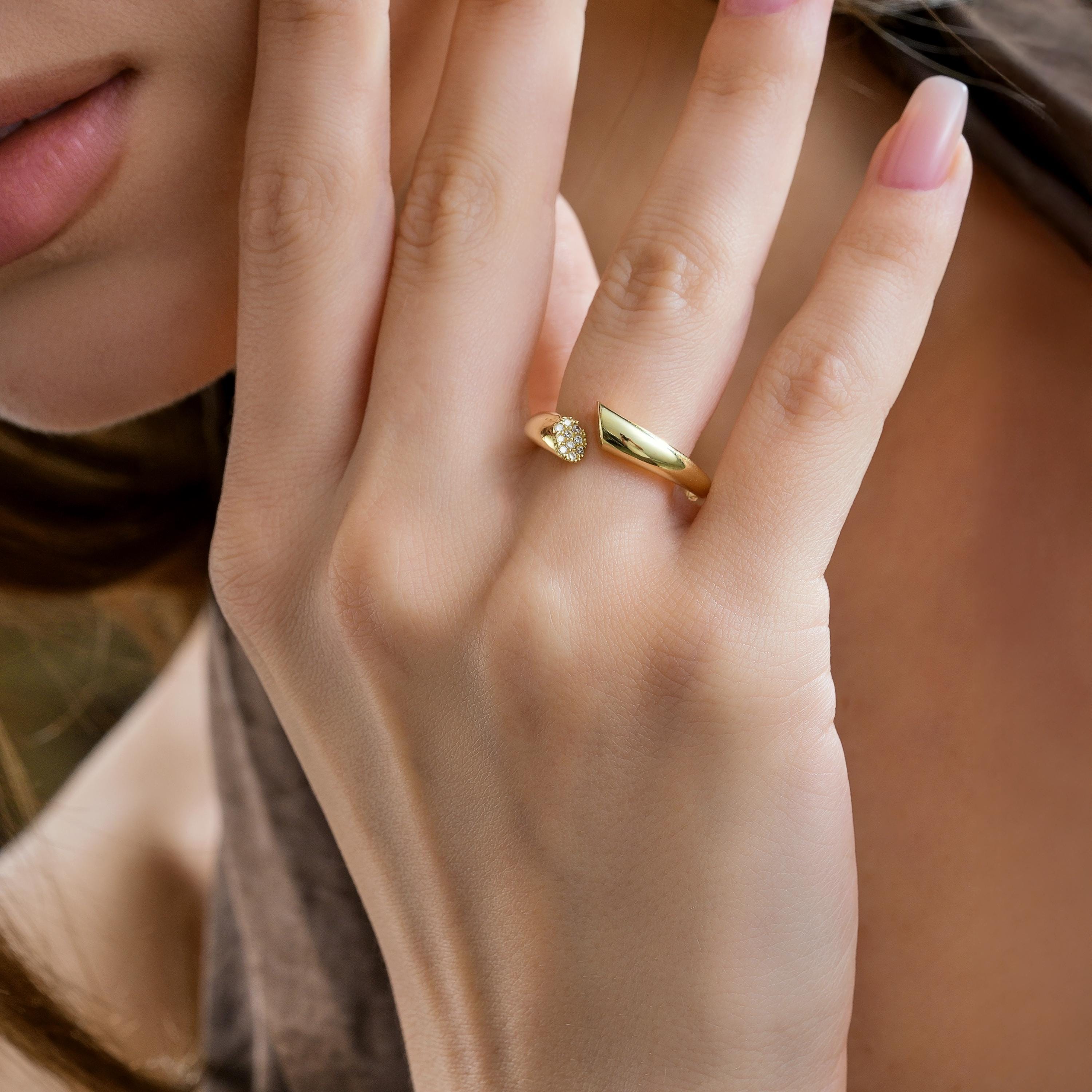 Model wearing solid gold open cuff ring with pavé CZ diamond round tip and polished pointed end