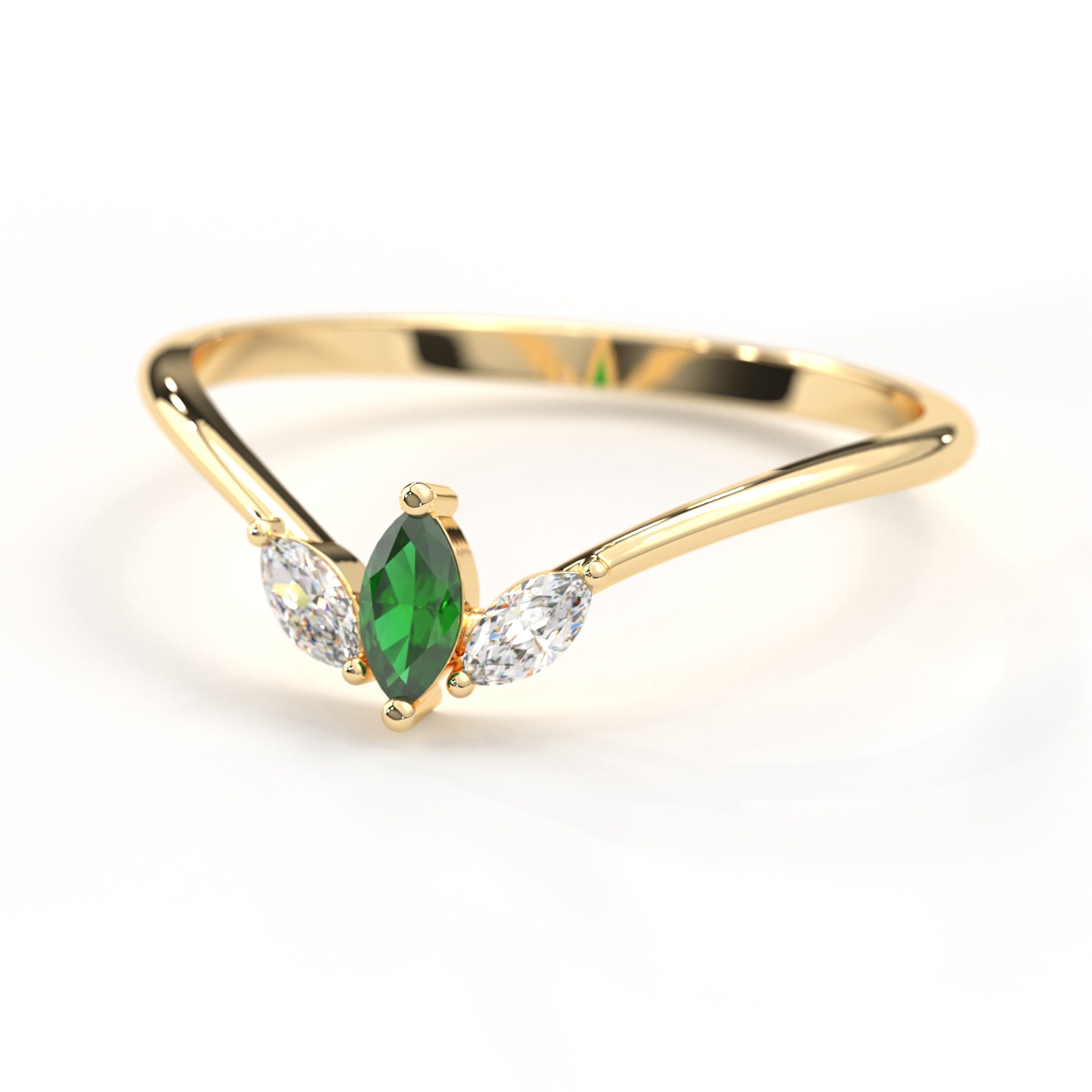 May include: A gold ring with a marquise shaped green gemstone and two smaller marquise shaped white gemstones