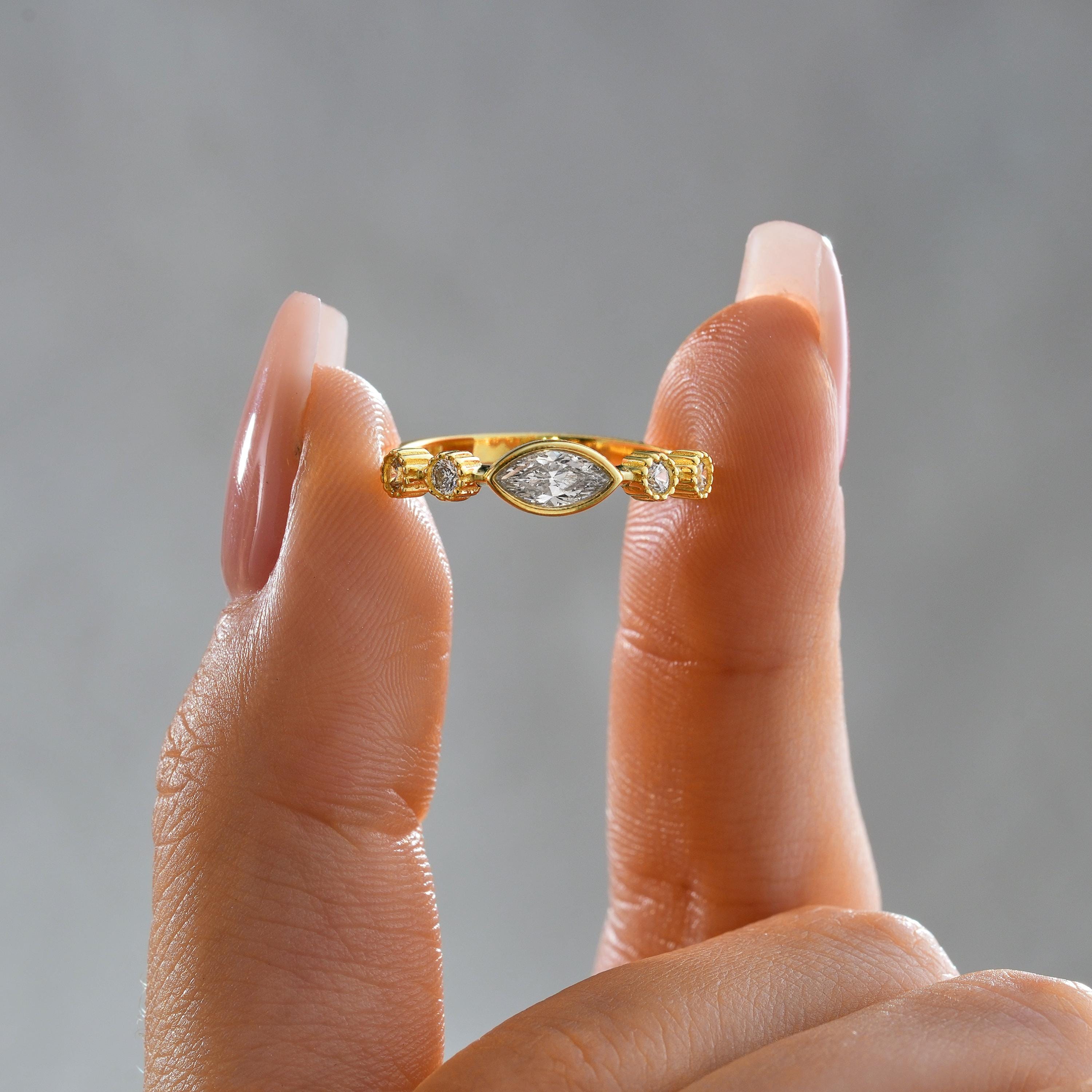 solid gold marquise bezel ring with round milgrain side diamond stones