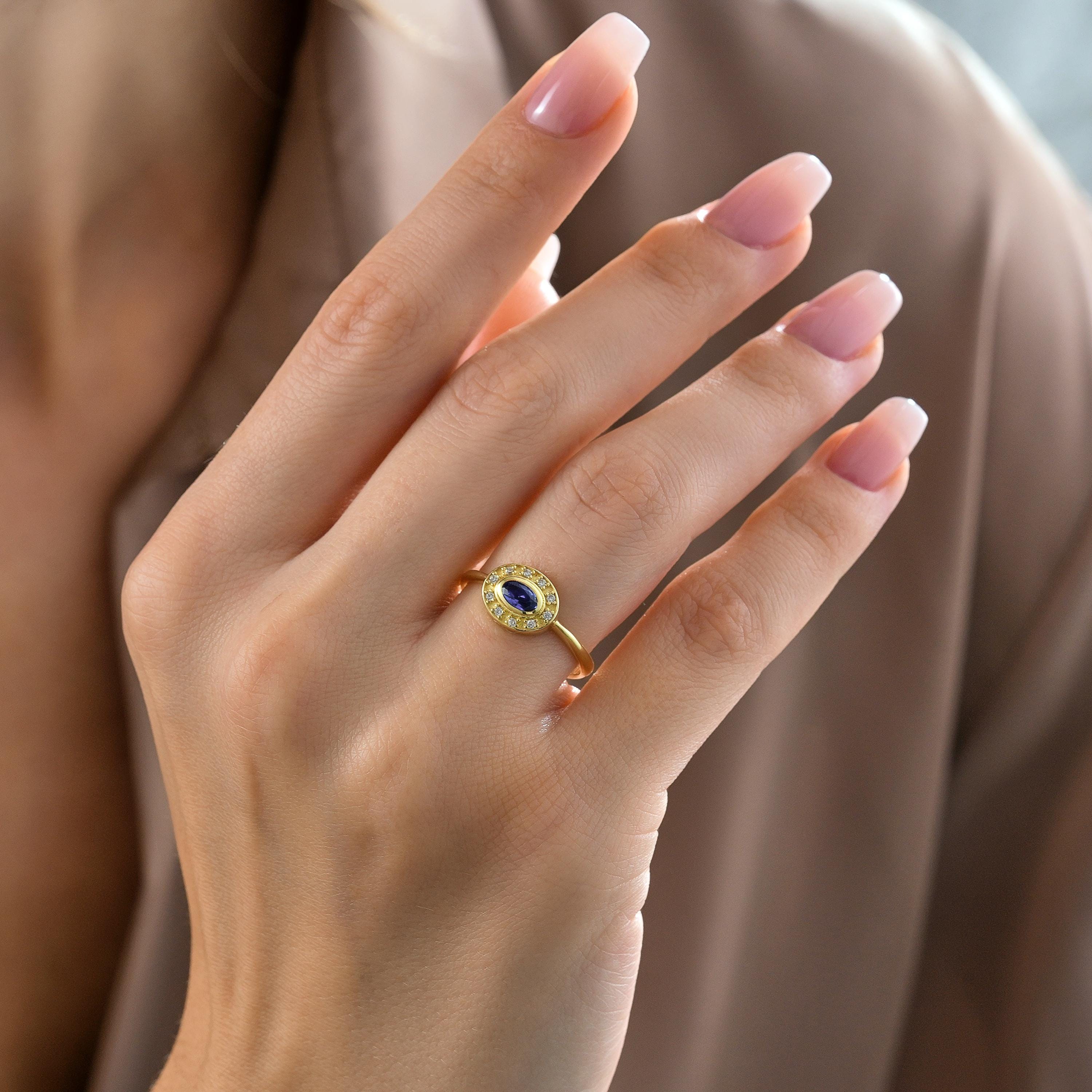 solid gold oval sapphire bezel halo ring